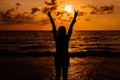 Silhouette of Happy woman showing two fingers while sunset at sea,Overcoming obstacle concept Royalty Free Stock Photo