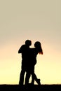 Silhouette of Happy Young Couple Dancing at Sunset Royalty Free Stock Photo