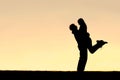 Silhouette of Happy Young Couple Hugging Outside at Sunset Royalty Free Stock Photo