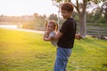 A silhouette of a happy young mother harmonious family outdoors. laughing and playing in the summer on the sunset background. Royalty Free Stock Photo