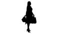 Silhouette Happy young woman making a turn with shopping bags in Royalty Free Stock Photo