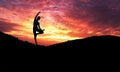 Silhouette of healthy woman practicing yoga meditation during on background mountain with sky and sunset Royalty Free Stock Photo