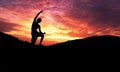 Silhouette of healthy woman practicing yoga meditation during on background mountain with sky and sunset Royalty Free Stock Photo