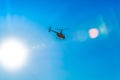 Silhouette of helicopter in blue clear sky with solar patches of light. Warm spring day. Modern transport. Royalty Free Stock Photo