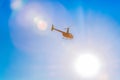 Silhouette of helicopter in blue clear sky with solar patches of light. Warm spring day. Modern transport. Royalty Free Stock Photo