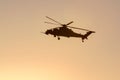 Silhouette of a helicopter flying against a sunset sky. Royalty Free Stock Photo