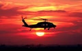 A silhouette of a helicopter flying against the vibrant hues of a sunset sky, emanating a sense of freedom and adventure Royalty Free Stock Photo