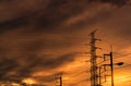 Silhouette high voltage electric pylon and electrical wire with an orange sky. Electricity poles at sunset. Power and energy