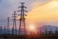 Silhouette high voltage electric pylon and electrical wire with an orange sky. Electricity poles at sunset. Power and energy