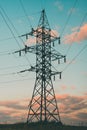 Silhouette of high voltage electrical pole against a sunset sky. Vertical orientation Royalty Free Stock Photo