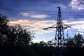 Silhouette of a high-voltage power line tower against cloudy sky in the evening Royalty Free Stock Photo