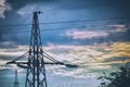 Silhouette of a high-voltage power line tower against cloudy sky in the evening Royalty Free Stock Photo