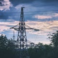 Silhouette of a high-voltage power line tower against cloudy sky in the evening Royalty Free Stock Photo