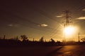 Silhouette of high voltage tower with electrical wires on sunset background. View through the grass. Power line support in a field Royalty Free Stock Photo