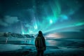 Silhouette of a hiker admiring the view of aurora borealis in beautiful Icelandic nature. Sky with stars and green polar lights.