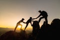 Silhouette of Hikers climbing up mountain cliff. Climbing group helping each other while climbing up in sunset. Concept of help Royalty Free Stock Photo