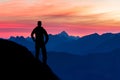 Silhouette of hiking man enjoying beautiful blue mountain ranges silhouettes and pink clouds. Alps, Allgau, Tirol