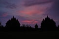 Silhouette of Hindu temple buildings during sunset with purple and red colours