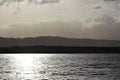 Silhouette horizon with cloudy sky and sun reflected in the sea