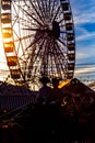 Silhouette of horse carriage and Ferris wheel at sunset. Seville`s April Fair.