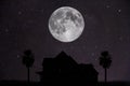 silhouette of a house with a full moon and trees