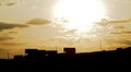 Silhouette houses with brown sky and sun