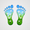 Silhouette of human footprints with grass and flowers inside