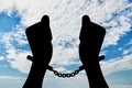 Silhouette of human hands in handcuffs