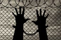 Silhouette of human hands in handcuffs