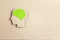 Silhouette human head with green brain on brown paper background