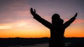 Silhouette of human person hands open palm up worship in sky sunset or sunset. Catholic adult man pray and hope on mountain. Royalty Free Stock Photo