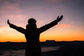 Silhouette of human person hands open palm up worship in sky sunset or sunset. Catholic adult man pray and hope on mountain. Royalty Free Stock Photo