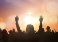 Silhouette human raising hand to praying God on blurred white cross with golden bokeh sunset background Royalty Free Stock Photo