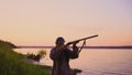 Silhouette of the hunter on a duck hunt near a beautiful lake. Shooting hunter.