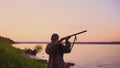 Silhouette of the hunter on a duck hunt near a beautiful lake. Shooting hunter. Royalty Free Stock Photo