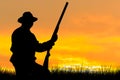 A hunter with a gun in his hands in hunting clothes in the autumn forest in search of a trophy.