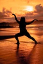 silhouette image of an Asian woman doing ballet movements very flexibly on the beach