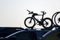 Silhouette image of bikes on car rooftop rack. Auckland