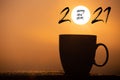 Silhouette image coffee cup with text happy new year 2021 on a sunrise background Royalty Free Stock Photo