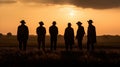 Silhouette image of a group of farmers standing together in a field at sunset