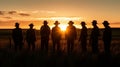 Silhouette image of a group of farmers standing together in a field at sunset