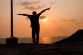 the silhouette image of a happy boy near ocean with sky in the background Royalty Free Stock Photo