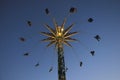 Silhouette image of people swinging high in the sky on an amusement park ride in the evening Royalty Free Stock Photo