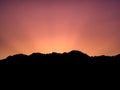 Silhouette image - sunlight behind the mountain at sunrise Royalty Free Stock Photo