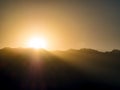 Silhouette image - sunlight behind the mountain at sunrise Royalty Free Stock Photo