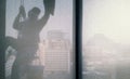 Silhouette images of man cleaning the window office building Royalty Free Stock Photo