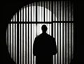 A silhouette of an individual behind bars manifesting the fear of captivity. Art concept. AI generation