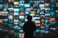 A silhouette of an individual examines a colorful array of social media screens in a contemporary setting during the Royalty Free Stock Photo