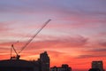 Silhouette of industrial construction crane at sunrise
