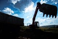 Silhouette of industrial excavator loading earth